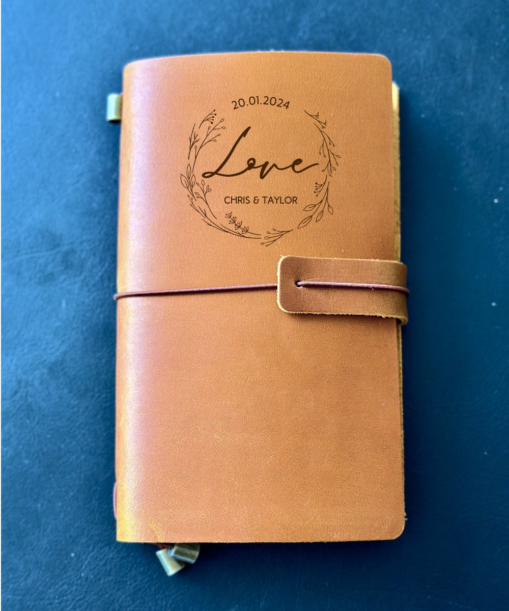 Leather diary with custom cover beside anniversary bouquet