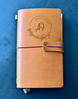 Handcrafted leather wedding planner on planning desk