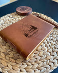 a brown leather book sitting on top of a woven basket