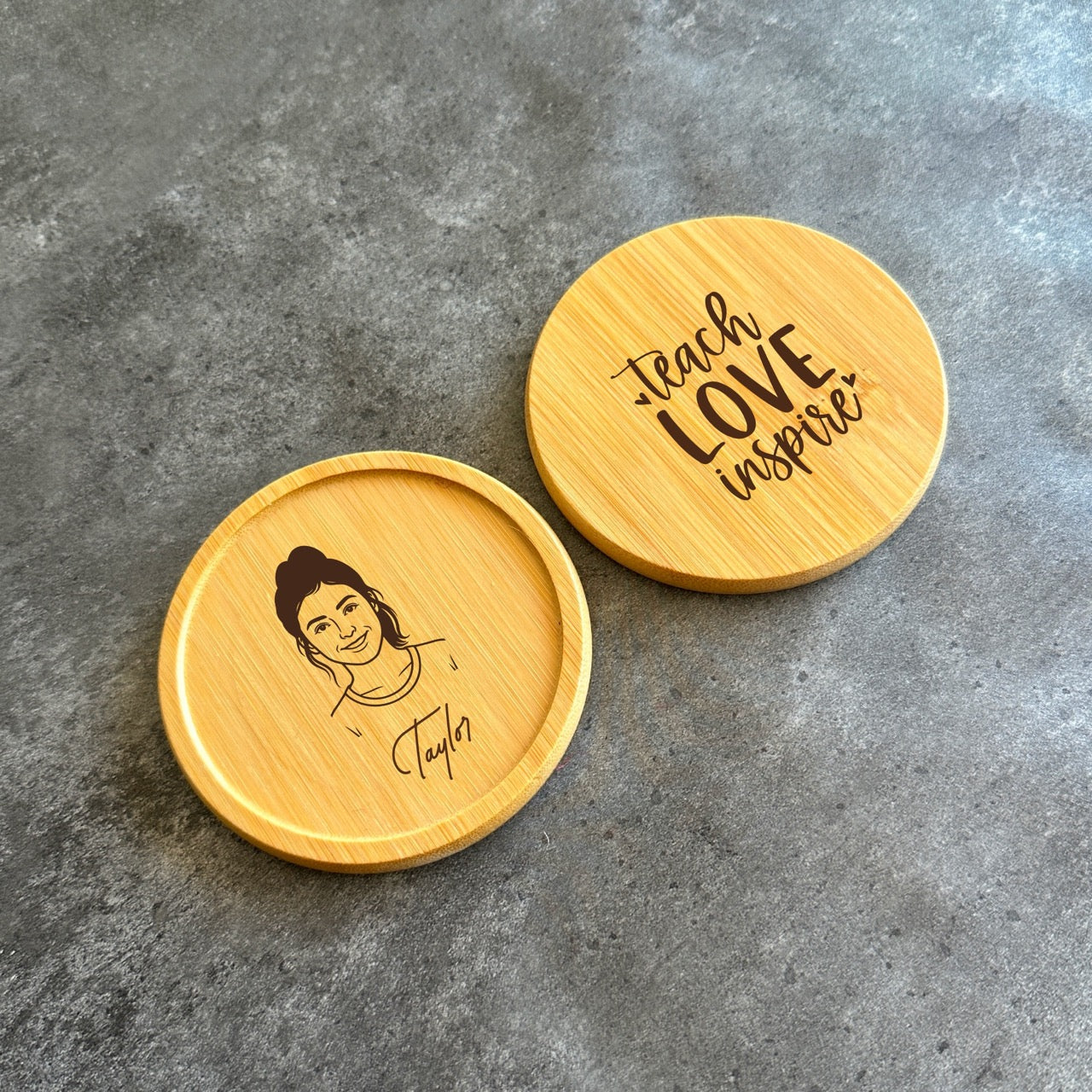 Two wooden coasters with printed text and a portrait of a person on them.
