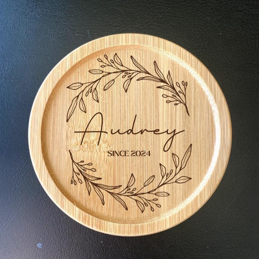 Engraved wooden coaster with floral design and couple initials for wedding guests