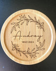 Engraved wooden coaster with floral design and couple initials for wedding guests