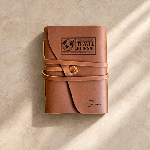 Leather wrap travel journal engraved with a globe design and a couple’s names.