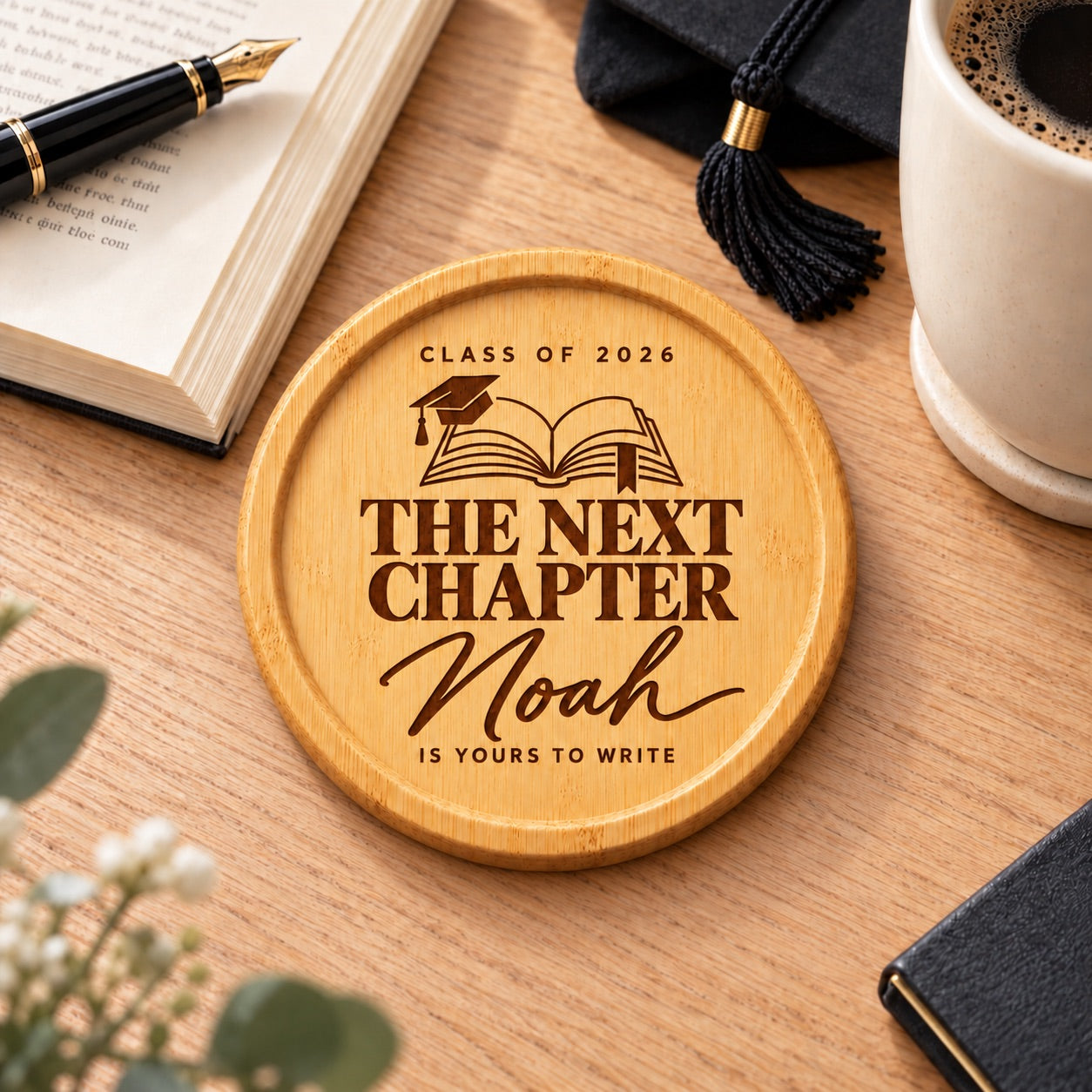 Personalised graduation coaster featuring an open book, graduation cap, custom name and The Next Chapter wording
