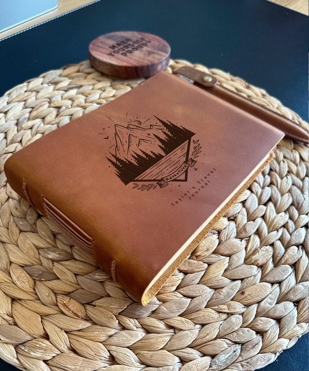 Handmade leather journal with engraved mountain and forest crest design